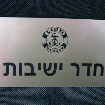 שלט חרוט מאלומיניום כסוף מוברש עבור חדר ישיבות של חברת מעגן. שלטים חרוטים למשרד עם לוגו חברה וטקסט בולט בחריטה שחורה איכותית.